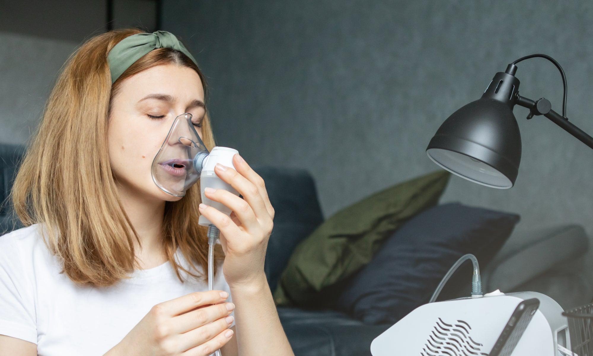 woman uses nebulizer machine at home