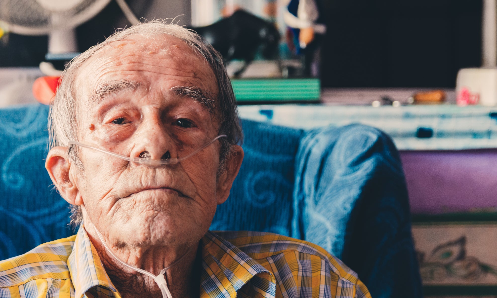 old man wearing oxygen cannula at home